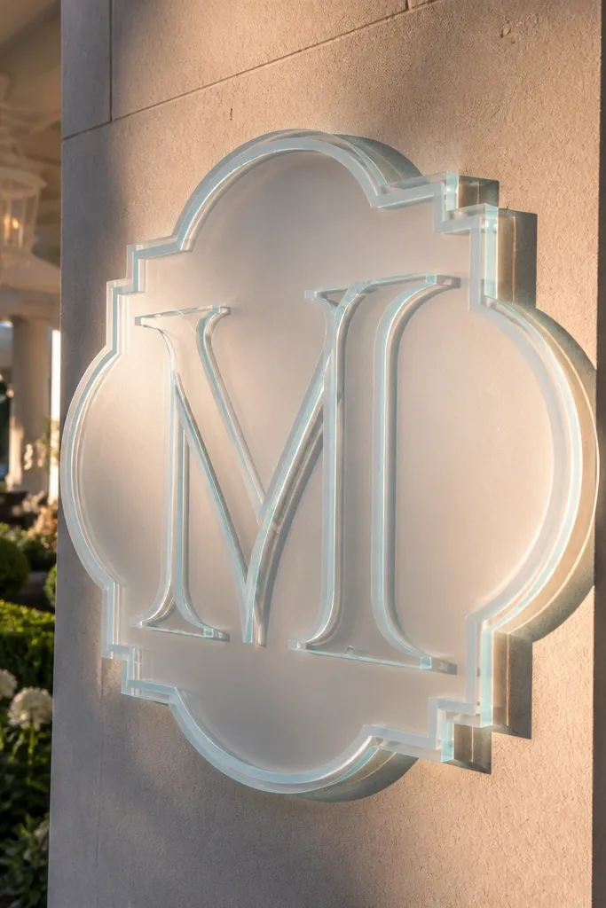 Layered acrylic sign with a large monogram on a frosted backing