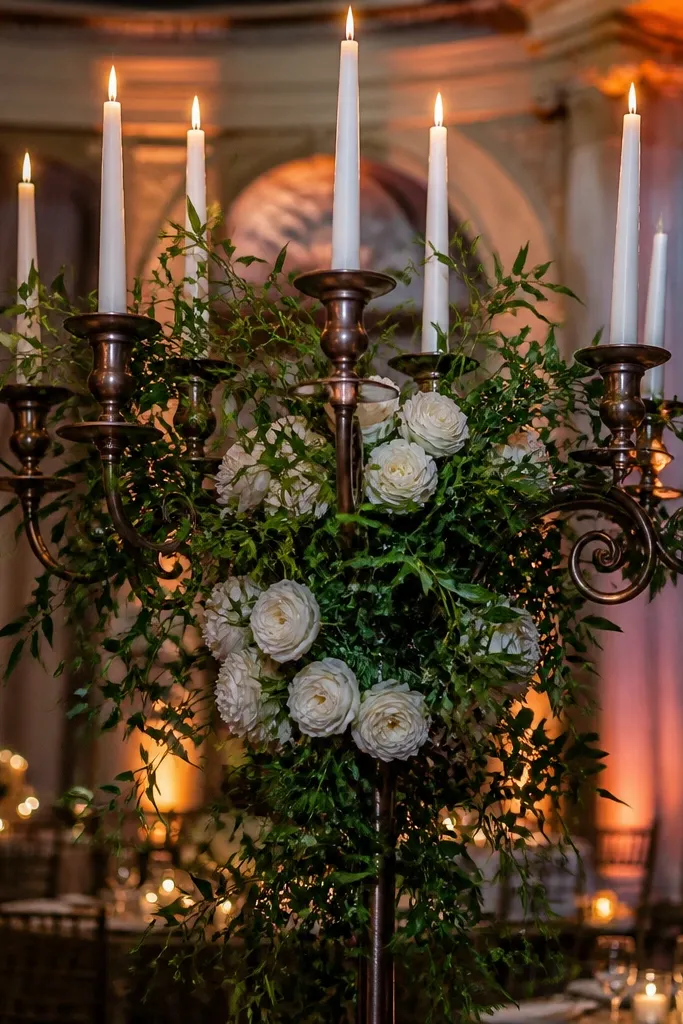 Gold candelabra with tall candles and a single-color floral swag