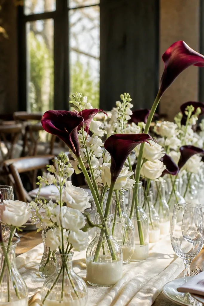 Cream bud vases with white flowers and one deep burgundy stem
