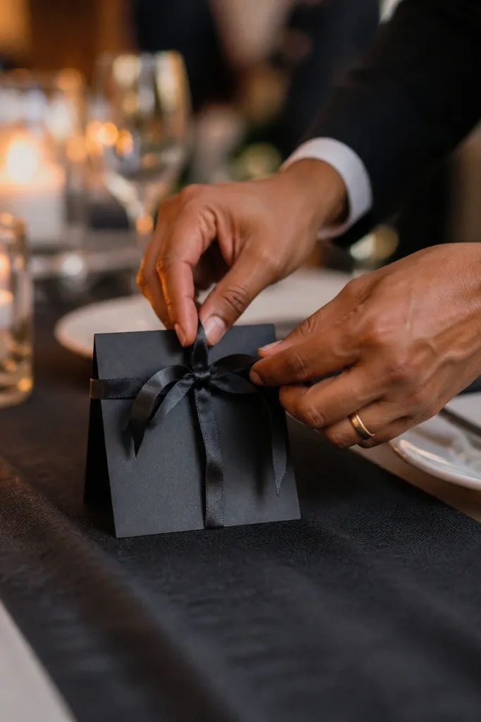 Hands holding rings near a table number card on a linen table